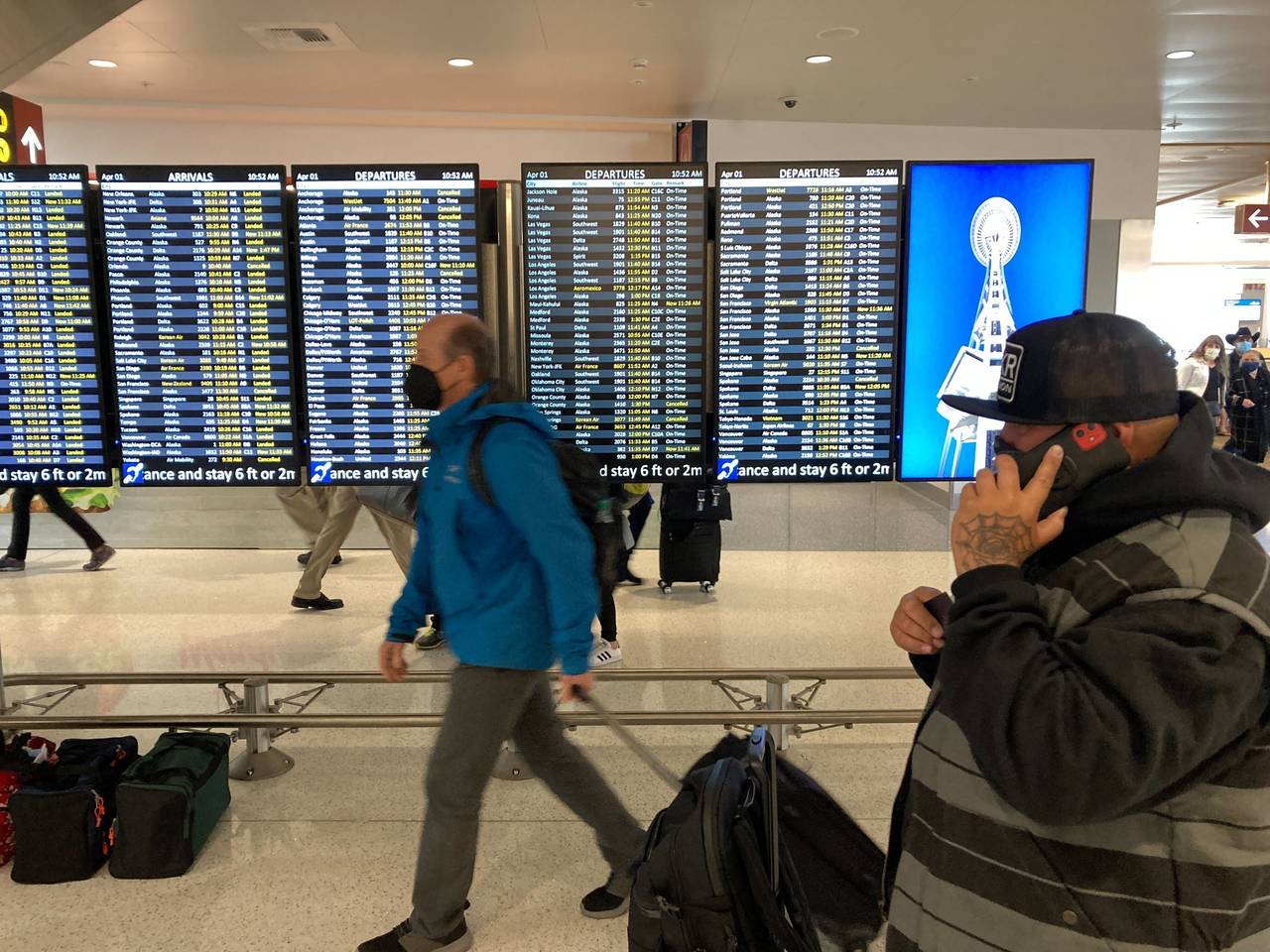 FILE - Travelers walk through Seattle-Tacoma International Airport on Friday, April 1, 2022 in Seat...