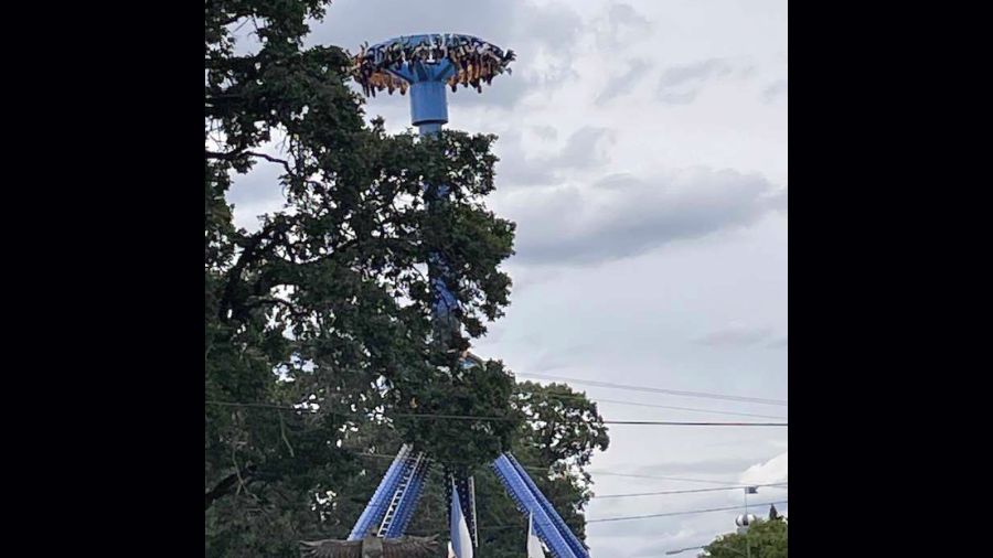 Photo: In this photo provided by Tieanna Joseph Cade, an amusement park ride is shown stuck with 30...