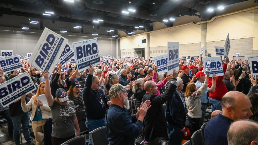 Image: A group of people in attendance at the Washington State Republican Party 2024 Convention hol...