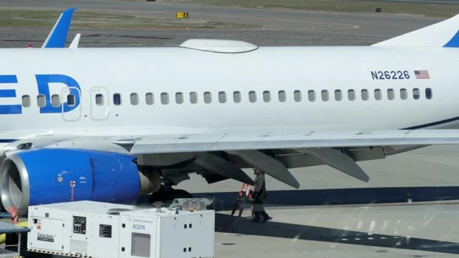 Image: Medford Jet Center staff investigate underneath a United AirlinesBoeing 737-824 that landed ...